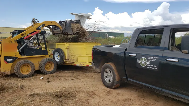 Green waste removal in Tucson: a skid steer loading brush into the trailer