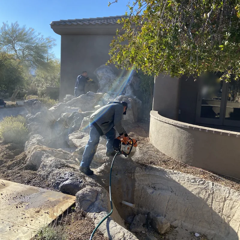 Concrete removal in Oro Valley: a crew member cutting out a concrete basin with a wet saw