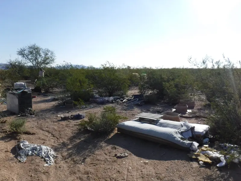 Debris hauling before: a mattress, cinder block and trash dumped in the desert