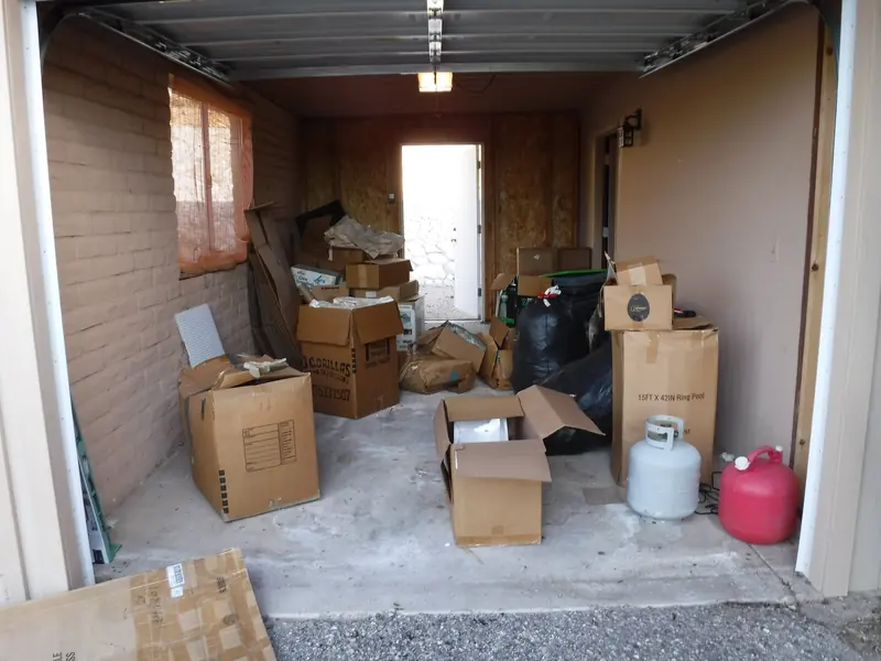 Garage clean out before: boxes, bags and trash filling a garage