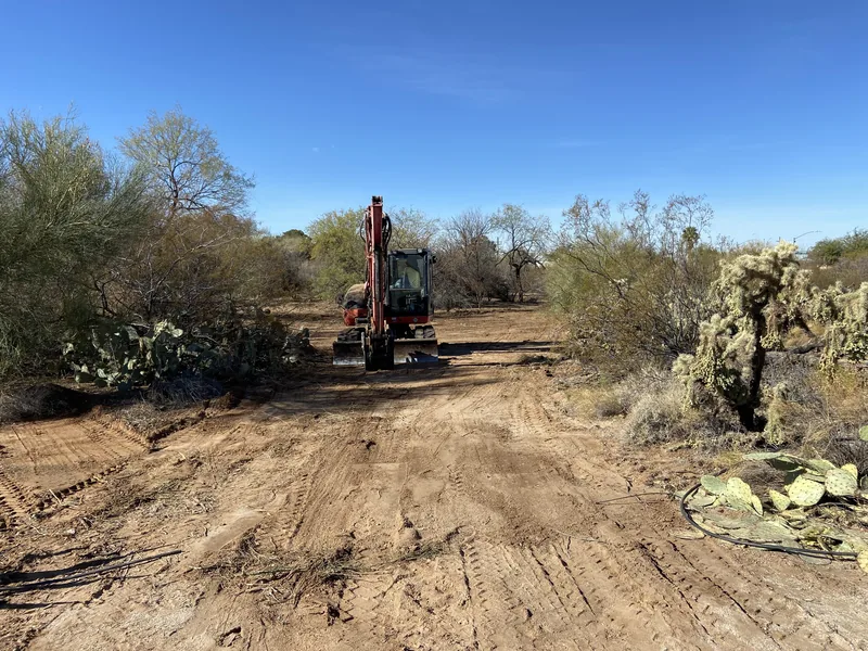 Land clearing in Tucson: a mini excavator on a lot cleared to dirt