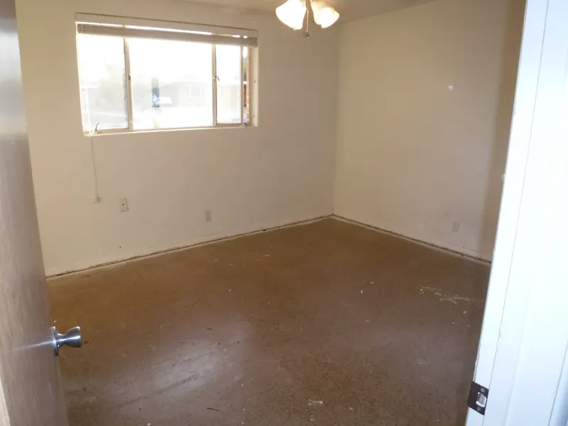 REO trash out, after: the bedroom emptied to the bare floor