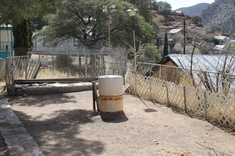 Storm debris cleanup, after: the dirt yard cleared and the lattice fence standing